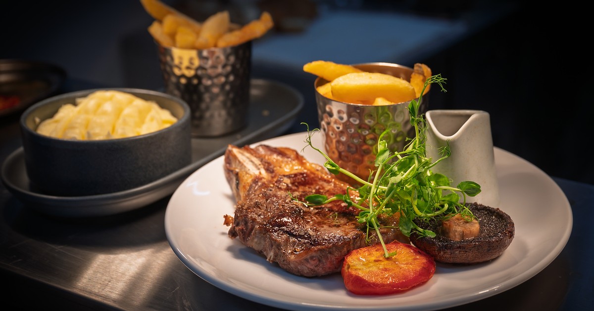 Sirloin steak with chips, mac and cheese, roasted tomato and sauce jug at The Fox at Walton, Wetherby